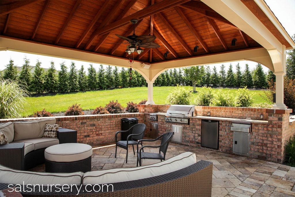Covered outdoor living area with kitchen and curved couch
