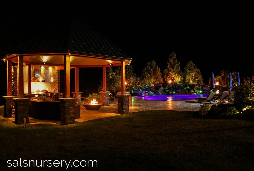Pool, Fire Pit, and outdoor kitchen at night with lighting