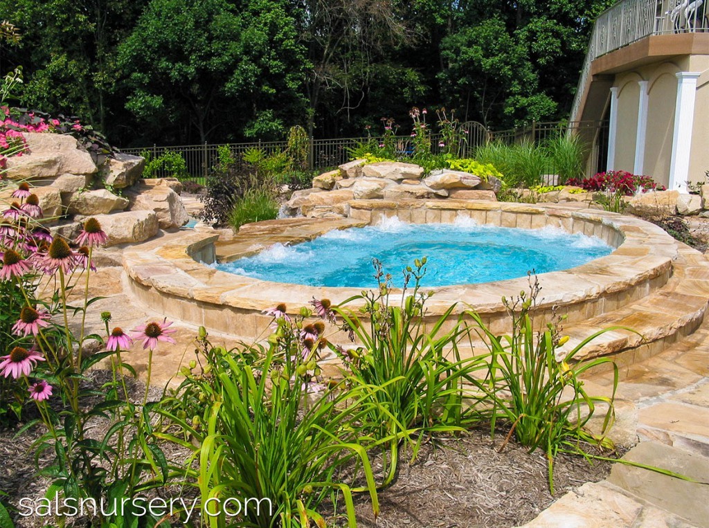 Natural looking in-ground hot tub with stone accents