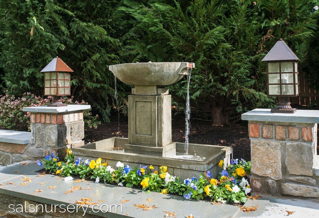 Water Fountain integrated into landscaping and surrounded by flowers